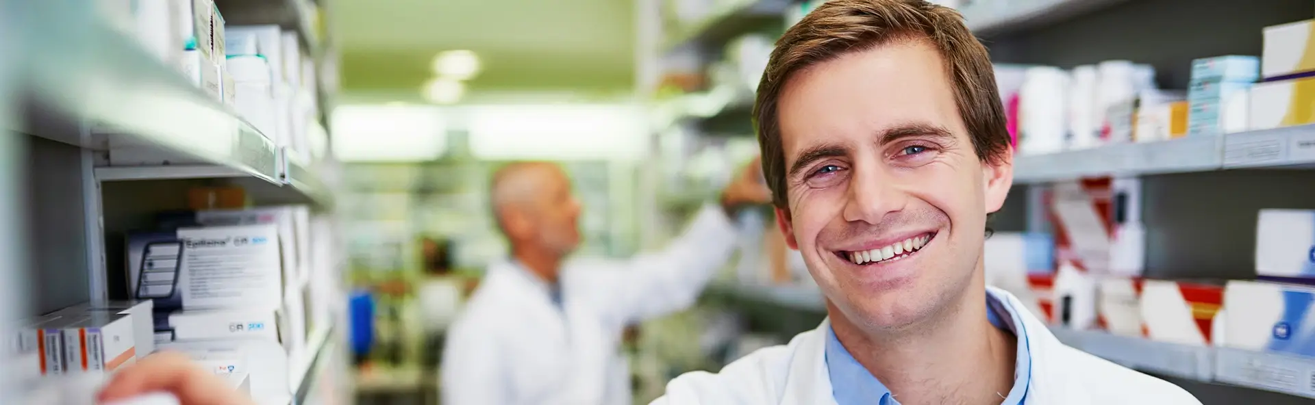 Mitarbeiter einer Apotheke bei Medikamentenregalen